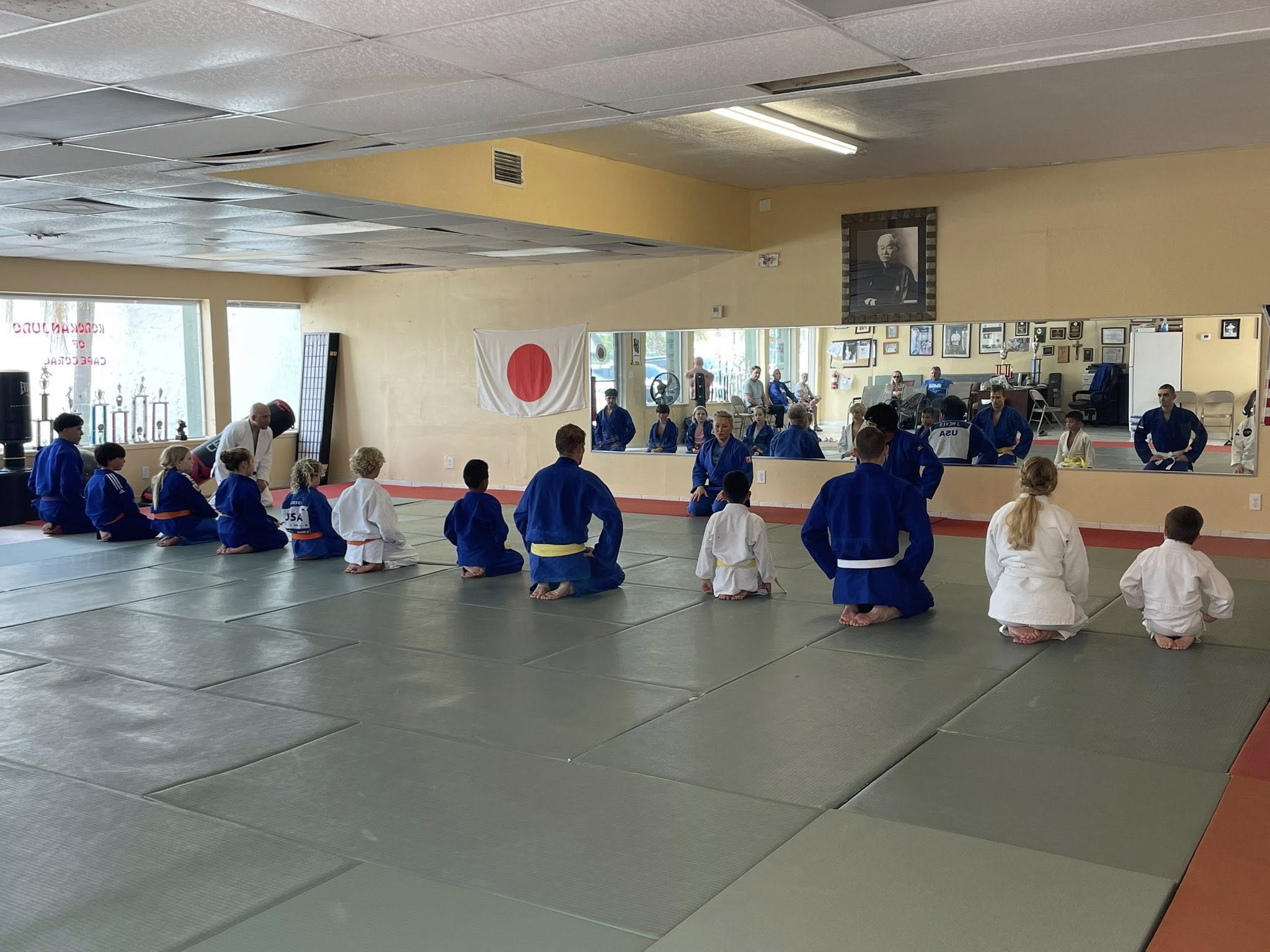 Young judoka bowing together on the judo mat