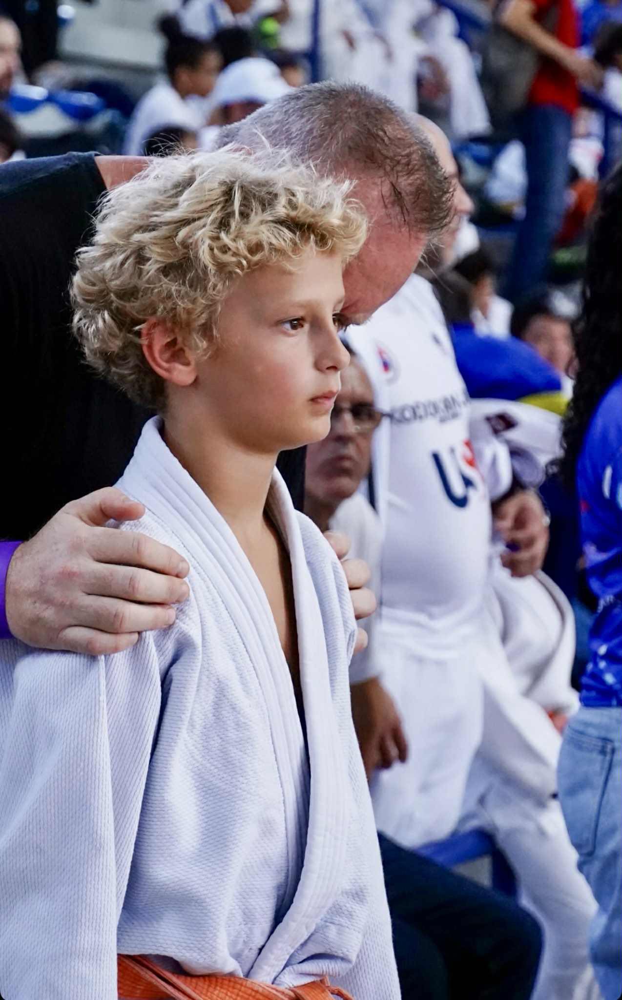 Coach guiding a young judoka at a national competition